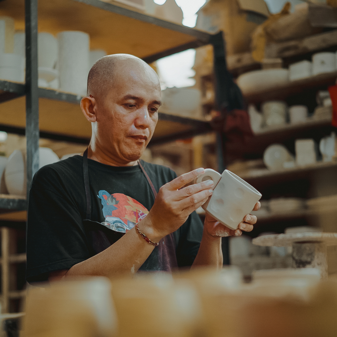 Ceramicist inspecting a hand-finished piece